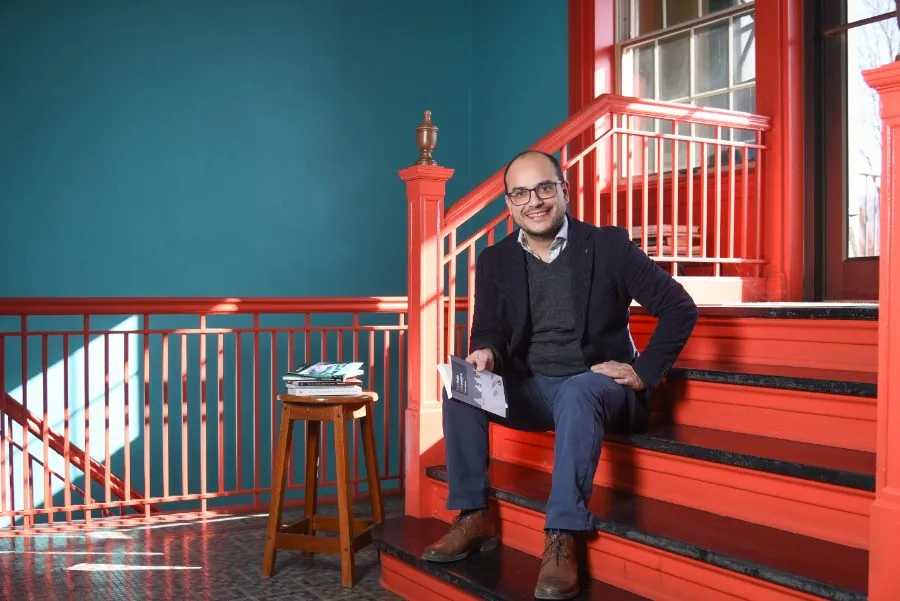 Man in a sweater sitting on red steps